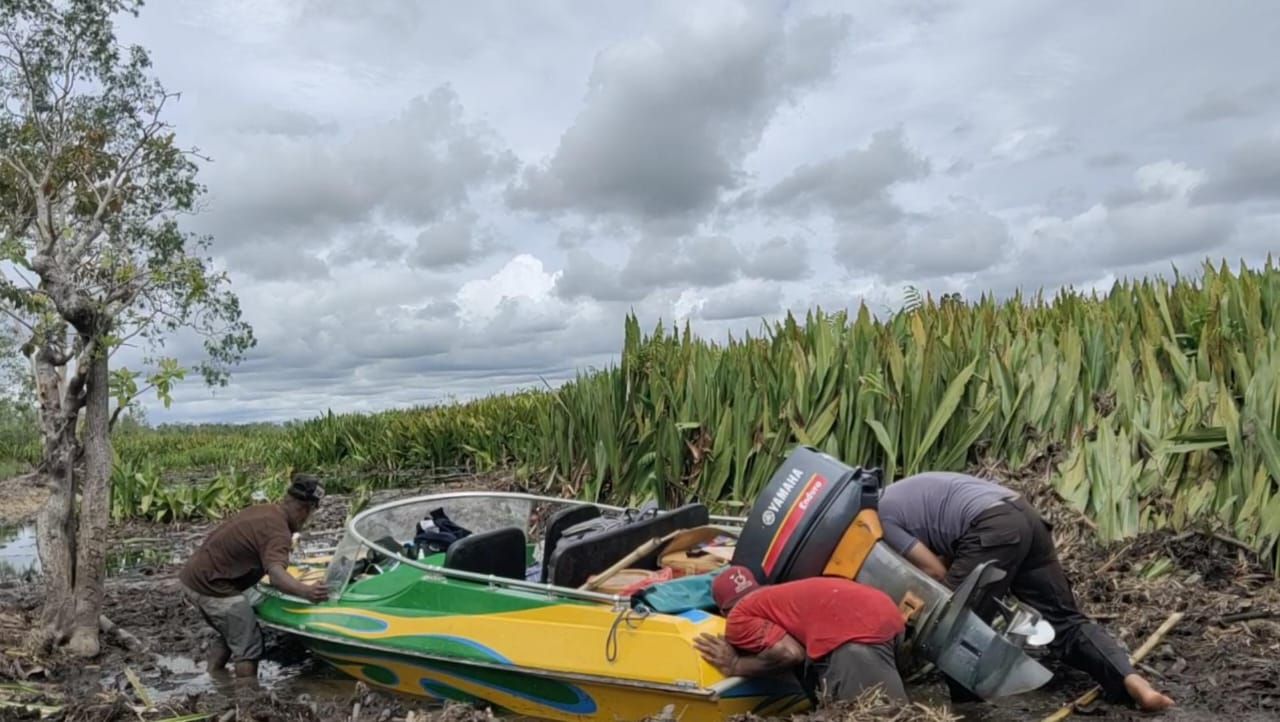 Bripka Hamdani bersama warga mendorong perahu cepat di tengah sungai yang dipenuhi tebu rawa. (Foto: dok)