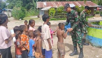 Personil Satgas Yonarmed 12 Kostrad Berbagi Bubur Kacang Hijau untuk Anak-Anak