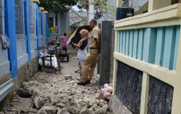 Petugas Gabungan Kelurahan Pulau Kelapa Memperbaiki Jalan Tergenang